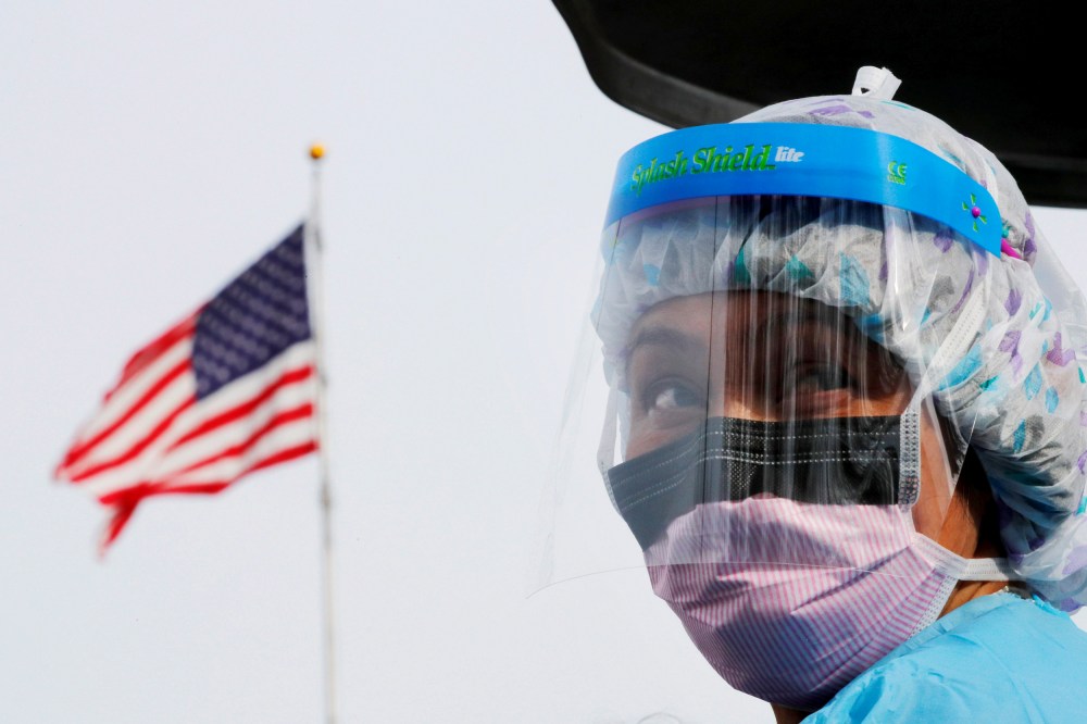 Image: A nurse wears protective gear at a drive-thru coronavirus testing site in Seattle on March 17, 2020.