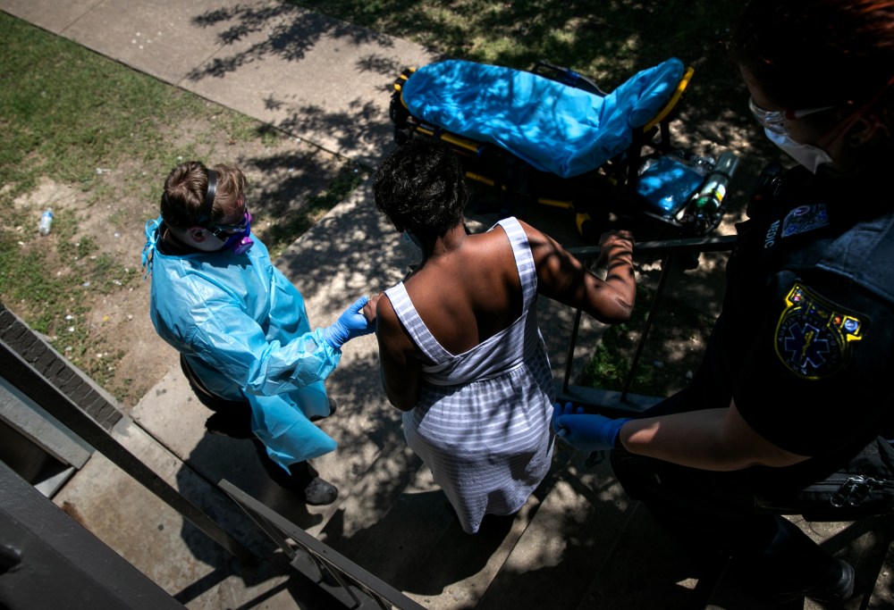 Image: Medics with Austin-Travis County EMS help a woman with Covid symptoms to a hospital in Texas on Aug. 4, 2020.
