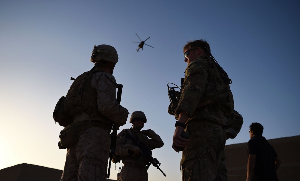 U.S. Marines and Afghan Commandos stand together as an Afghan Air Force helicopter flies past during a combat training exercise at Shorab Military Camp in Lashkar Gah in Helmand province, Afghanistan, on Aug. 27, 2017.