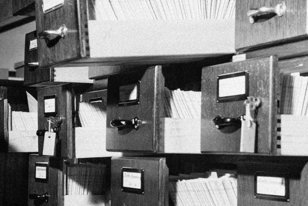 Image of stacks of open filing cabinets with papers.