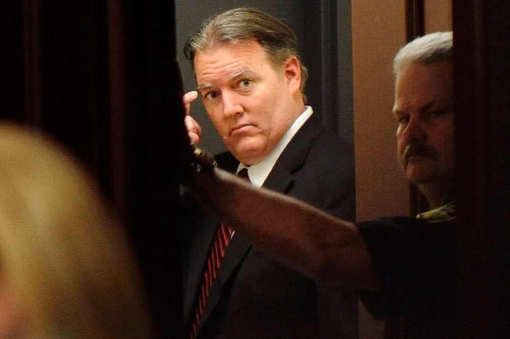 Michael Dunn stands and looks back into the courtroom from the holding area after the verdicts were announced in his trial in Jacksonville, Florida Feb. 15, 2014.
