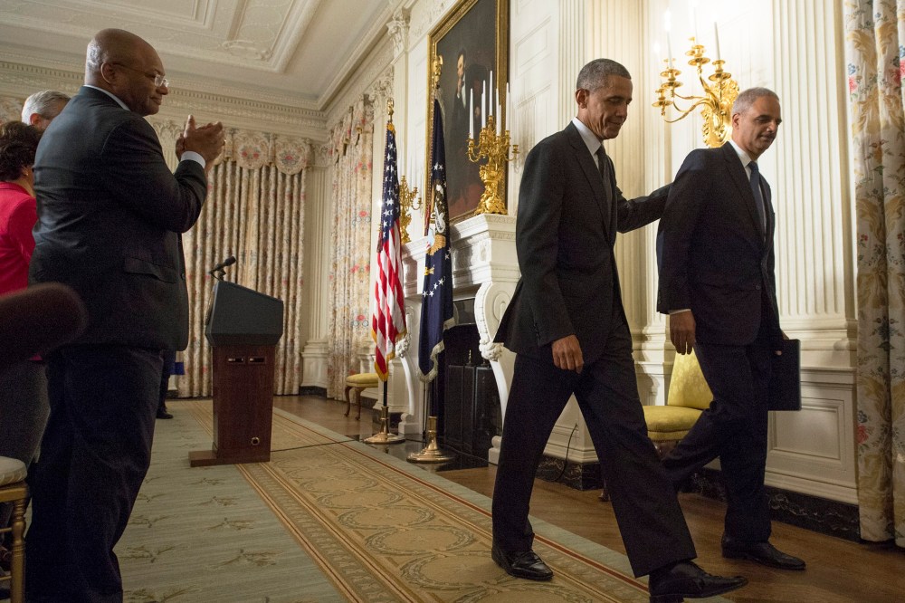 US President Barack Obama (2-R) and US Attorney General Eric Holder (R) walk away from the podium after they delivered remarks on Holder's resignation, at the White House, in Washington on Sept. 25, 2014.