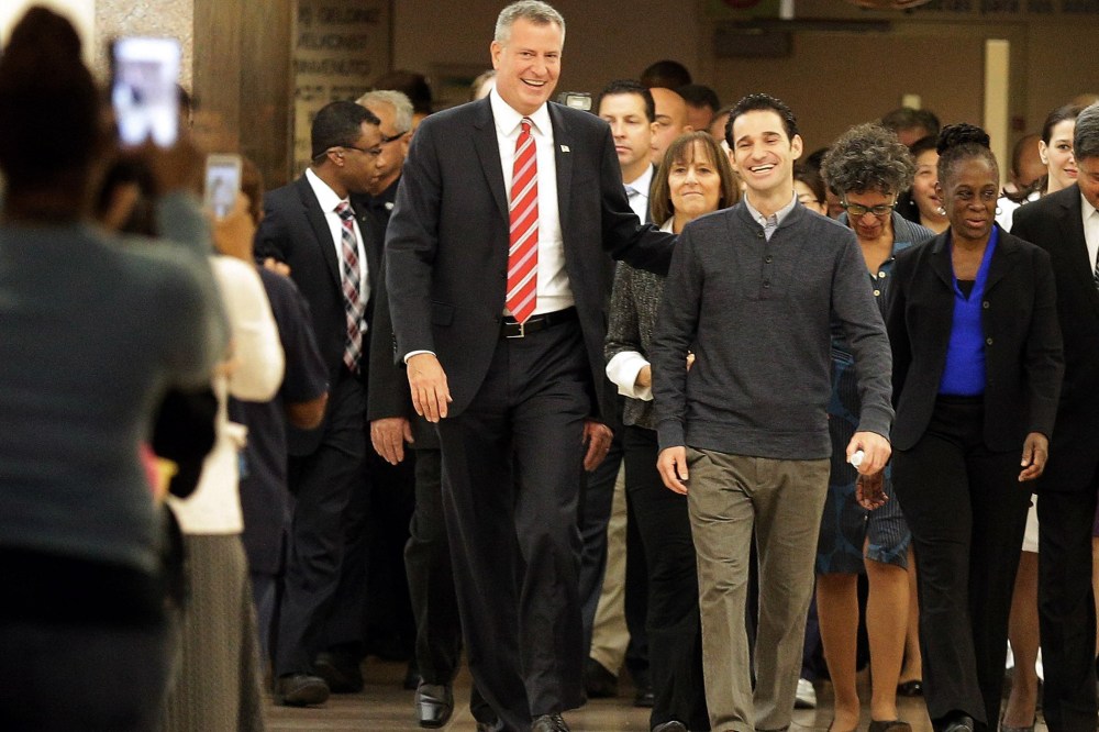 New York City Mayor Bill de Blasio (left) and his wife Chirlane McCray (right) flank Dr Craig Spencer (C) as Spencer leaves Bellevue Hospital after being declared free of the Ebola virus in New York, on Nov. 11, 2014.