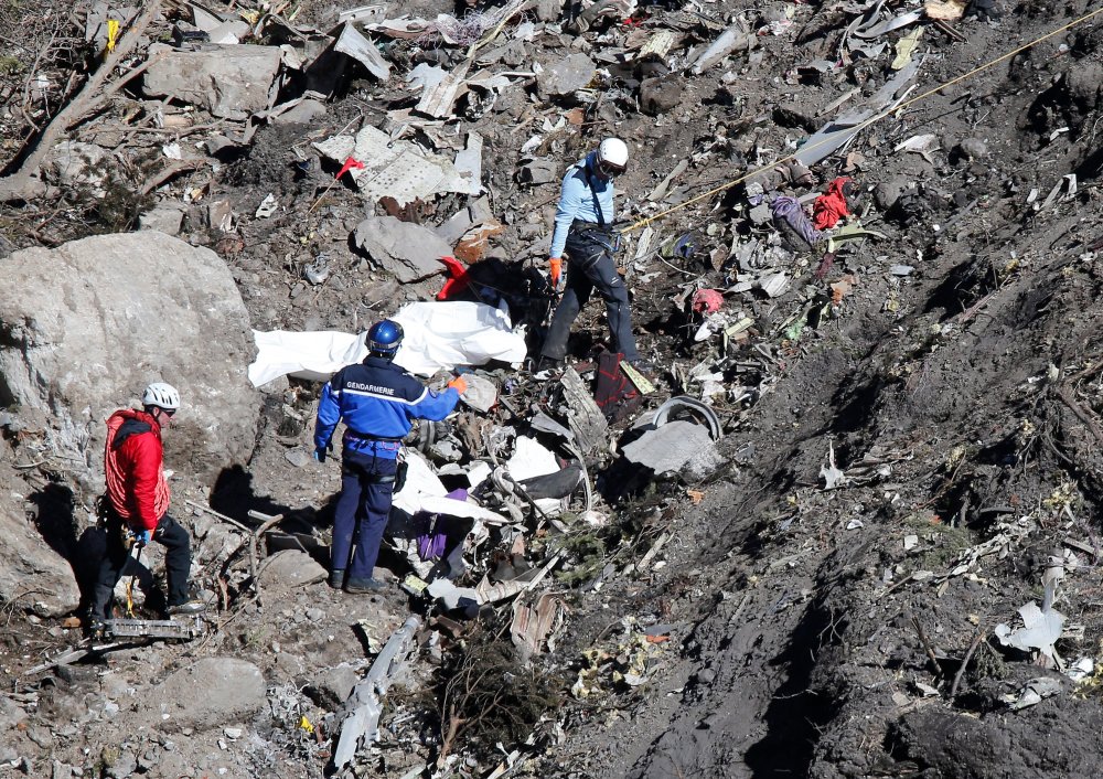Search and rescue workers make their way through debris at the crash site of the Germanwings Airbus A320 that crashed in the French Alps, above the town of Seyne-les-Alpes, southeastern France on March 26, 2015.