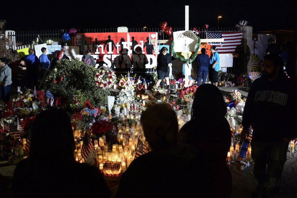 People gather around a makeshift memorial outside the Inland Regional Center where Syed Farook and wife Tashfeen Malik shot and killed 14 people, in San Bernardino, Calif., Dec. 7, 2015. (Photo by Mike Nelson/EPA)