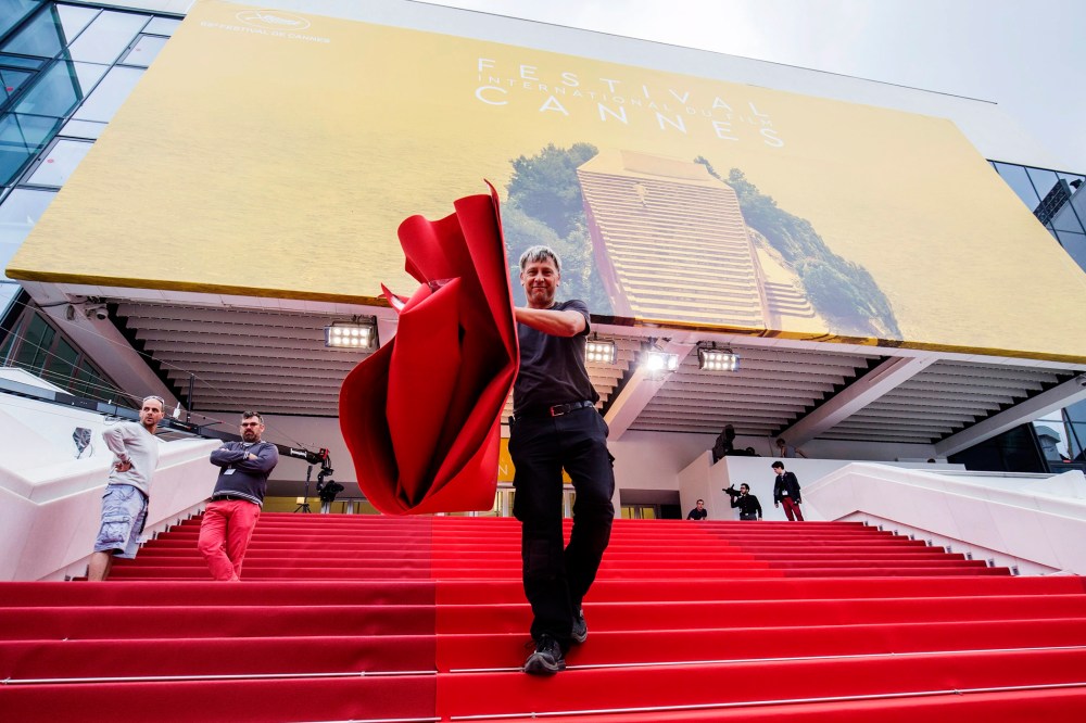 A worker installs the red carpet in front of the Festival Palace ahead of the 69th Cannes Film Festival, in Cannes, France, May 10, 2016. (Photo by Julien Warnand/EPA)