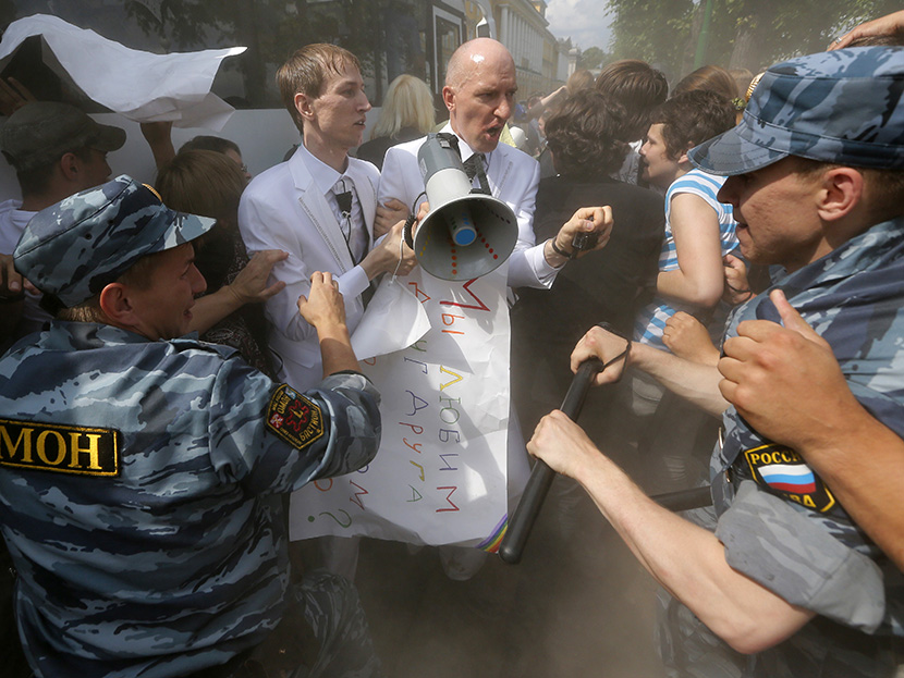 Riot police (OMON) officers detain gay rights activists Maxim Lysak and Jury Gavrikov during an authorized gay rights rally in St.Petersburg, Russia, Saturday, June 29, 2013. (Photo by Dmitry Lovetsky/AP)