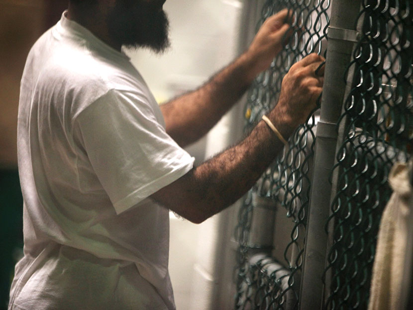 A detainee speaks through a fence at the U.S. detention center for "enemy combatants" on September 15, 2010 in Guantanamo Bay, Cuba.  (Photo by John Moore/Getty Images)