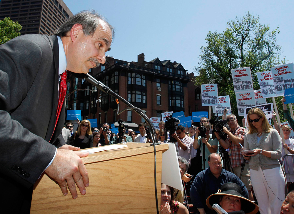U.S. President Barack Obama's campaign's senior strategist David Axelrod leans over the podium to listen to a reporter's question during a news conference held outside the Massachusetts State House in Boston, May 31, 2012.