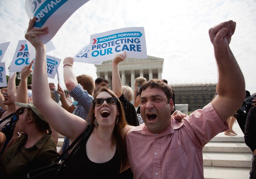 Claire McAndrew of Washington, left, and Donny Kirsch of Washington celebrate outside the Supreme Court in Washington, D.C., Thursday, after a the court's ruling on health care.