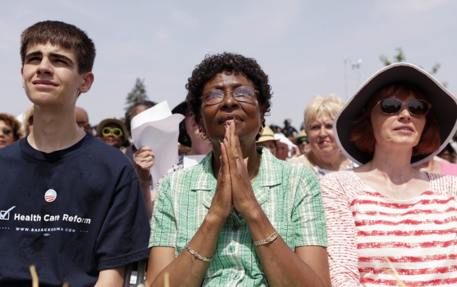 A woman clasps her hands as President Barack Obama speaks during a campaign event in Ohio July 5.