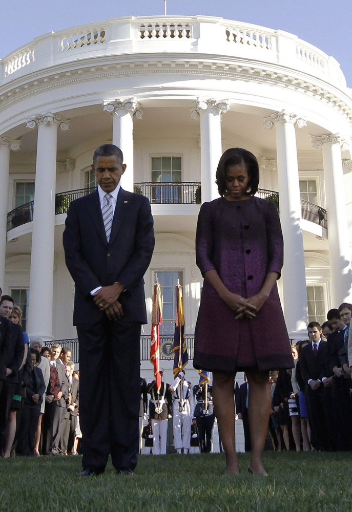 U.S. President Barack Obama and first lady Michelle Obama observe a moment of silence on the 11th anniversary of the September 11 attacks, on the South Lawn of the White House in Washington, September 11, 2012.