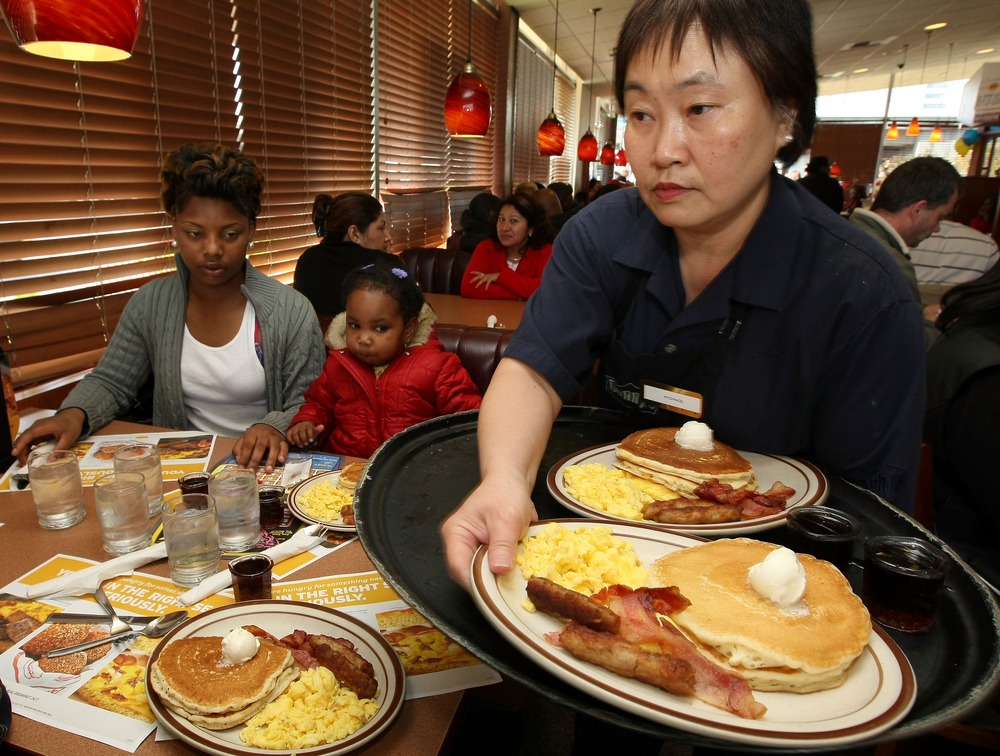 EMERYVILLE, CA - FEBRUARY 03: Denny's waitress Fong Van Luben (R) delivers free Grand Slam breakfasts to customers February 3, 2009 in Emeryville, California. (Photo by Justin Sullivan/Getty Images)
