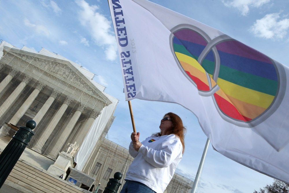 Same-sex marriage proponent Kat McGuckin of Oaklyn, New Jersey, holds a gay marriage pride flag while standing in front of the Supreme Court November 30, 2012 in Washington, DC (Photo by Chip Somodevilla/Getty Images)