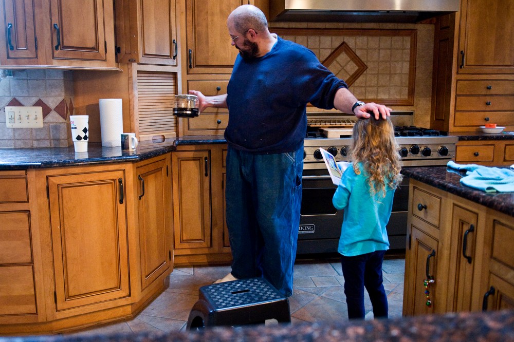 Keith Ohlinger, a stay at home dad and farmer in Maryland, pours a cup of coffee as his daughter Gabrielle, 4, asks him to read a story.
