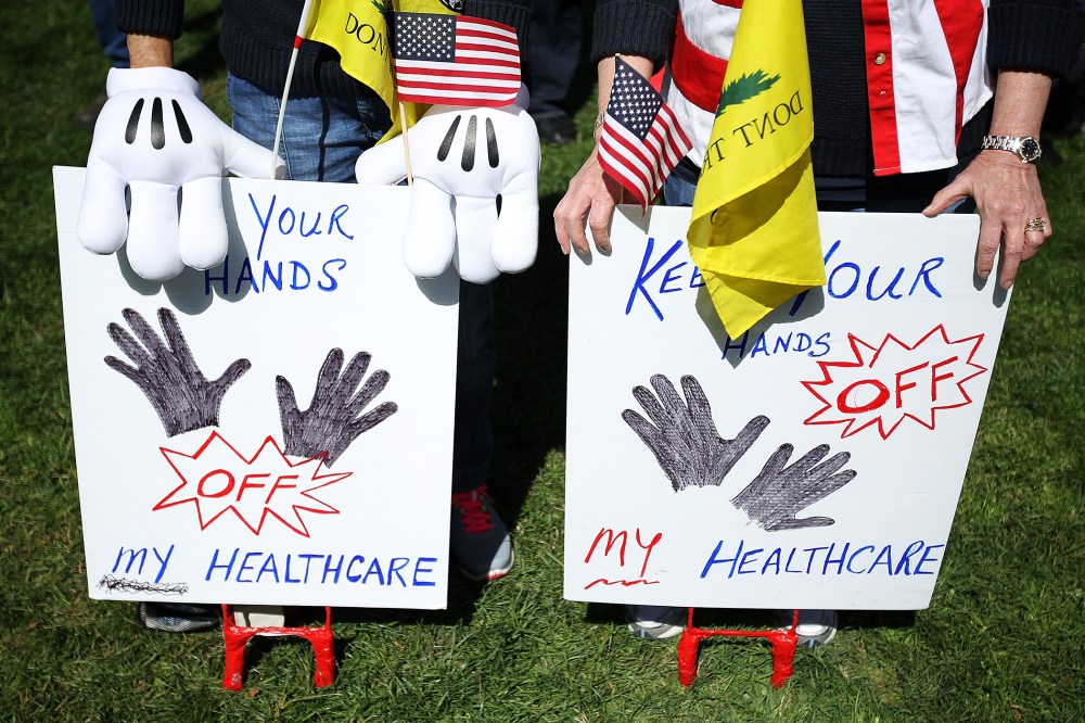 Tea Party supporters hold signs as they participate during a "Hands Off My Health Care" rally, March 27, 2012 on Capitol Hill in Washington, DC.