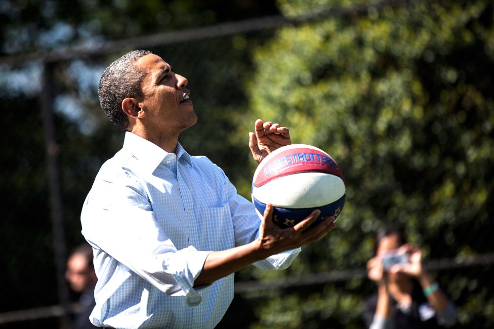 President Barack Obama shoots a basketball while participating in a basketball station with the Harlem Globetrotters during the annual Easter Egg Roll on the South Lawn of the White House April 9, 2012 in Washington, D.C. (Photo by Brendan Smialowski/AFP/
