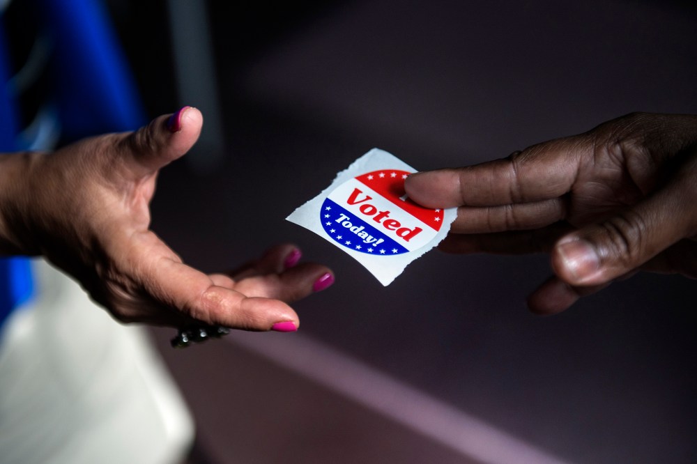 A poll worker hands out "I Voted Today" stickers on October 22, 2012.