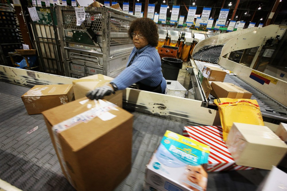 Bobbi Crump moves mail on a conveyor, December 17, 2012 in Elk Grove Village, Illinois.