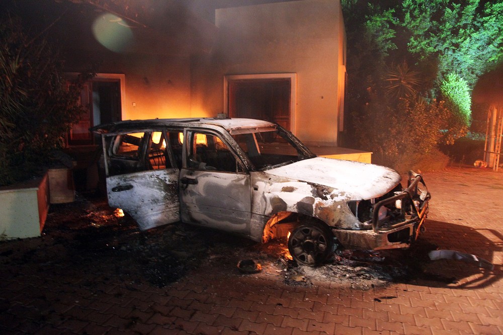 A vehicle and surrounding buildings smolder after they were set on fire inside the US mission compound in Benghazi., Sept. 11, 2012.