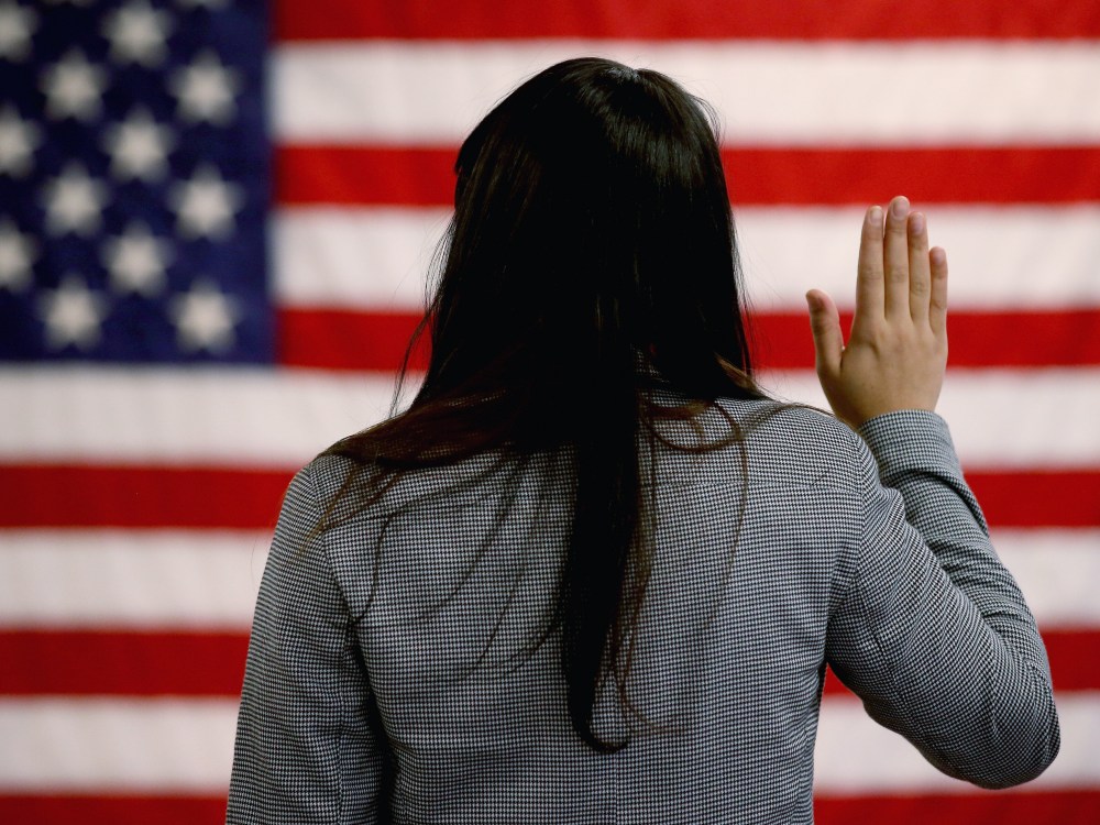 An woman takes the oath of allegiance during a naturalization ceremony at the at district office of the U.S. Citizenship and Immigration Services (USCIS) on January 28, 2013 in Newark, New Jersey. Some 38,000 immigrants became U.S. citizens at the...