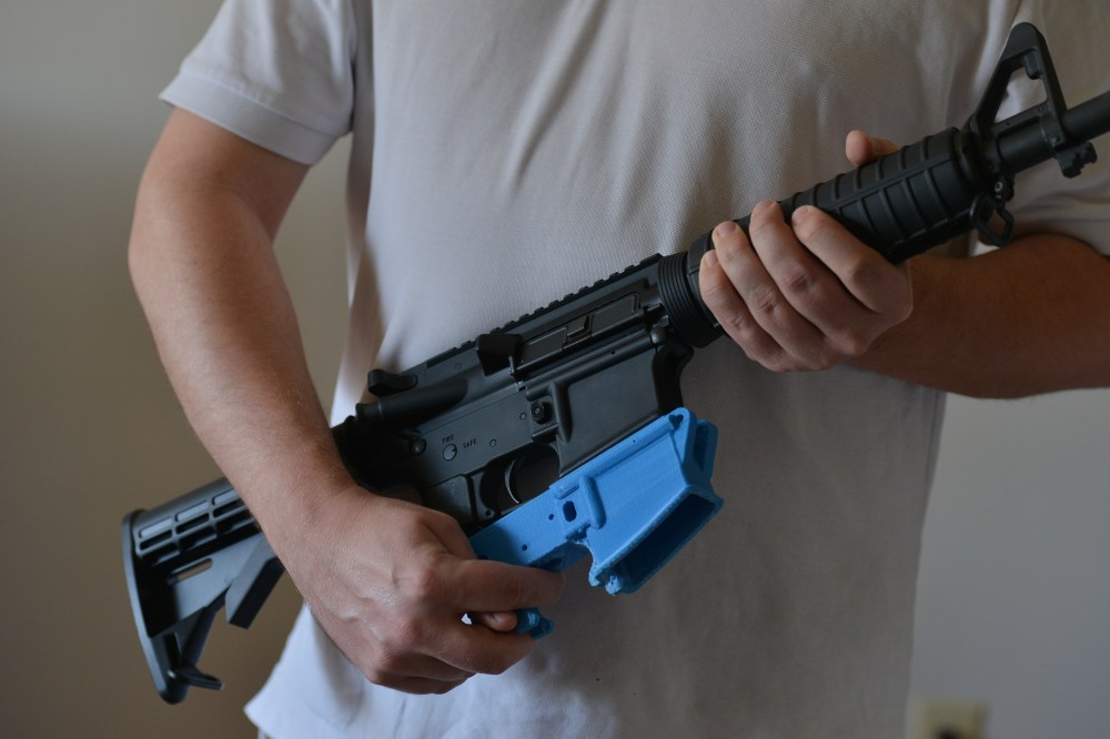 A man holds an AR-15 assault rifle with a lower receiver made of ABS (Acrylonitrile Butadiene Styrene) plastic constructed by a 3D printer, Feb. 12, 2012.