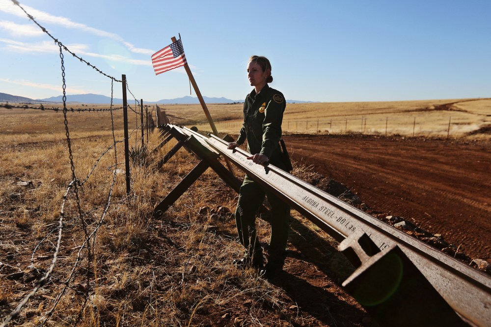 A U.S. Border Patrol agent looks into Mexico from the U.S.-Mexico border on February 26, 2013 near Sonoita, Arizona.