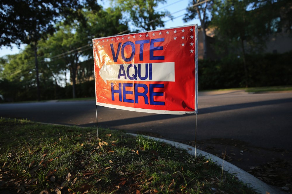 A bilingual sign stands outside a polling center at public library ahead of local elections on April 28, 2013 in Austin, Texas. (Photo by John Moore/Getty)