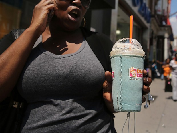 A woman walks down a street with an extra large drink in a Brooklyn neighborhood with a high rate of obesity and diabetes on June 11, 2013 in New York City.   (Photo by Spencer Platt/Getty Images)