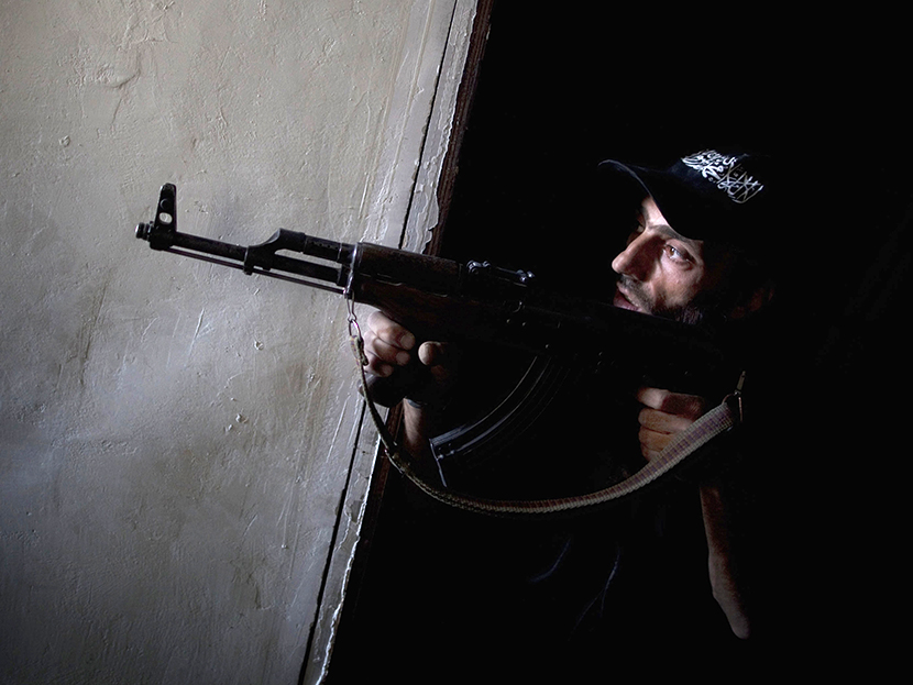 A rebel fighter points his gun towards pro-government forces' positions during clashes in the Salaheddine district of the northern Syrian city of Aleppo, on July 9, 2013.  (Photo by JM Lopez/AFP/Getty Images)