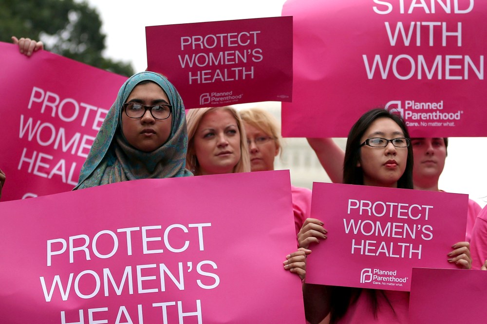 Women hold up signs during a women's pro-choice rally on Capitol Hill, July 11, 2013.