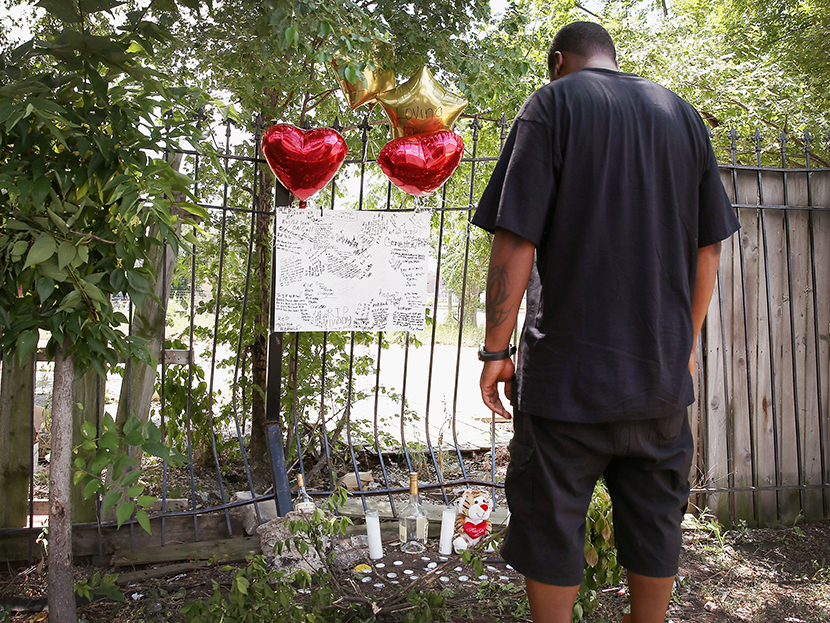 Anthony (no last name available) looks over a memorial for his friend Eugene Clark, 25, who was shot and killed Saturday on July 22, 2013 in Chicago, Illinois.  (Photo by Scott Olson/Getty Images)