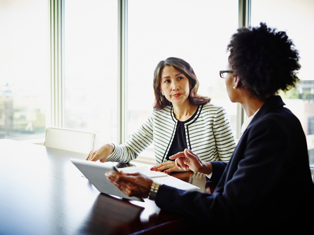 Businesswomen discussing project on digital tablet
