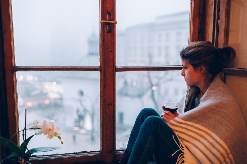 Image: Depressed woman sitting near the window