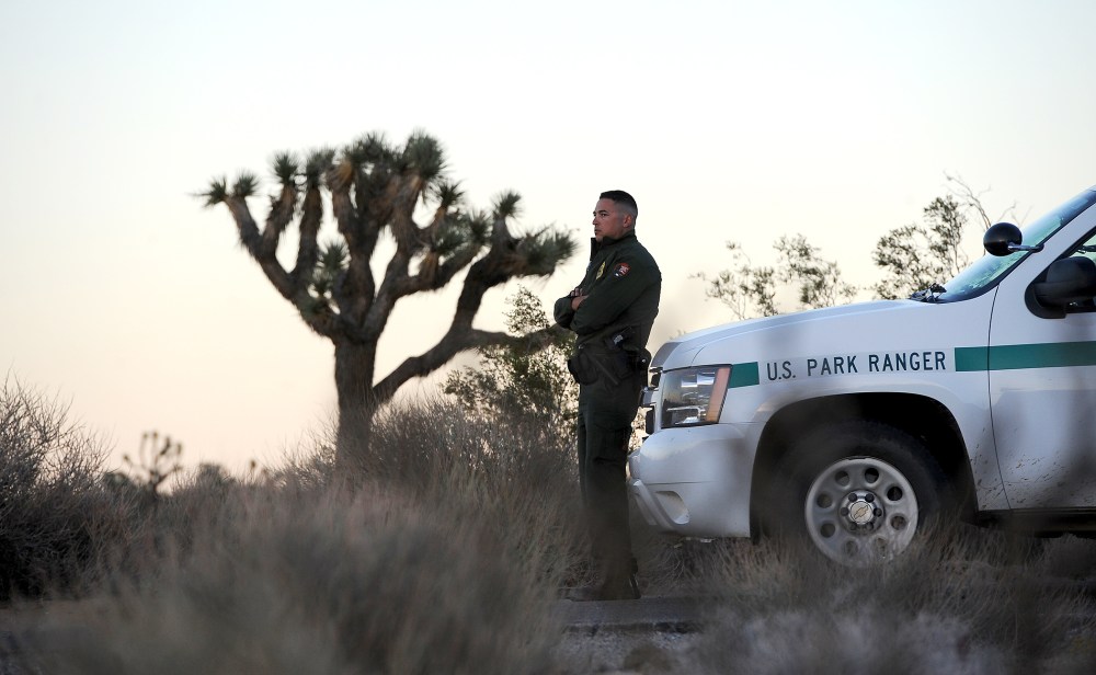 Park Ranger Dylan Moe stands guard as the sun sets at the entrance to Joshua Tree National Park