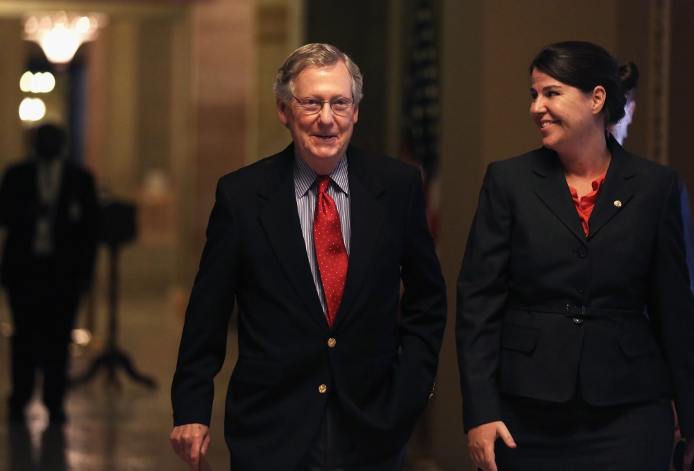 U.S. Minority Leader Senator Mitch McConnell (R-KY) walks towards the Senate Chamber with Secretary of the Minority Laura Dove October 7, 2013
