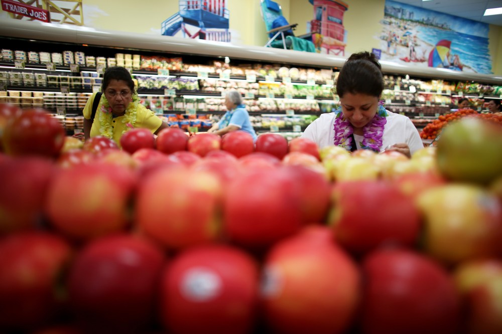 Shoppers look over the produce selection at Trader Joe's in Pinecrest, Fla.