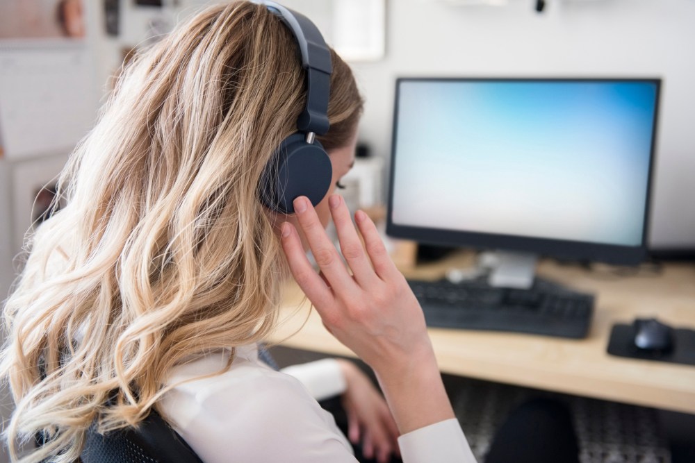 A woman with headphones at a desk