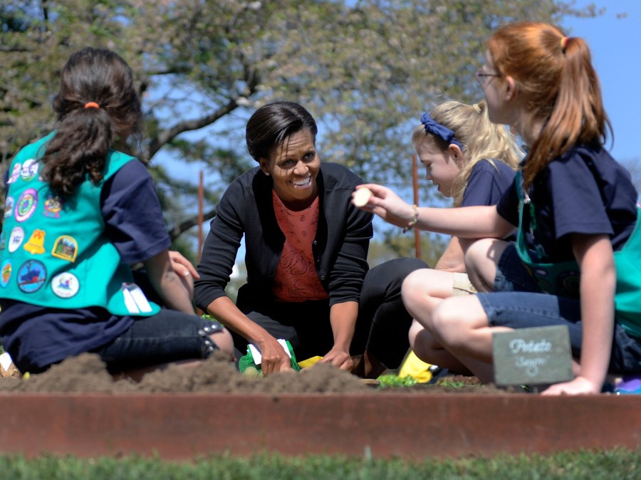 Image: U.S. first lady Michelle Obama works with school children who were invited to join her for the fourth annual White House Kitchen Garden spring planting on the South Lawn of the White House in Washington