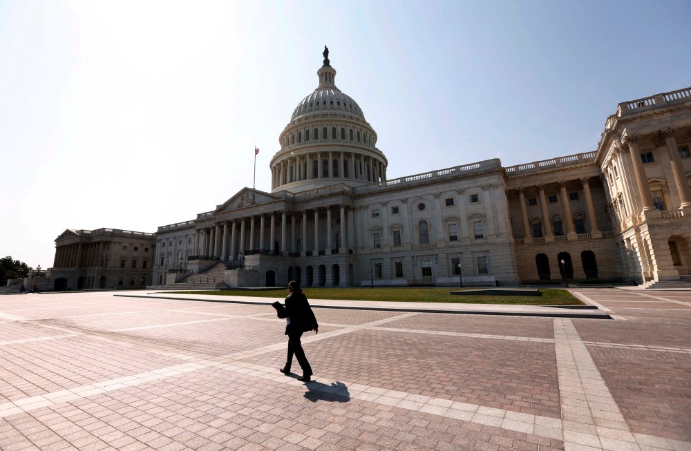 A woman walks past the U.S. Capitol in Washington September 25, 2012.