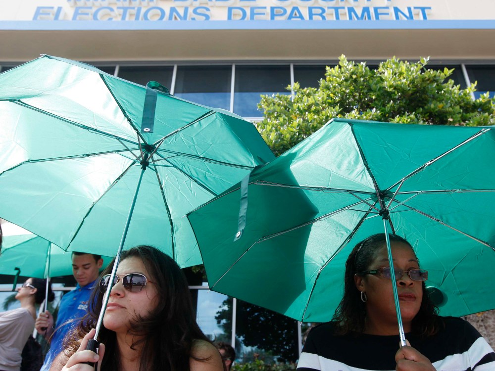 Yaine Noguera (L) and Sheron Reid wait in line to obtain and deposit their absentee ballots at the Miami-Dade County Elections Department Headquarters on the final day before Election Day, in Doral, Florida November 5, 2012. (Photo by REUTERS/Andrew...