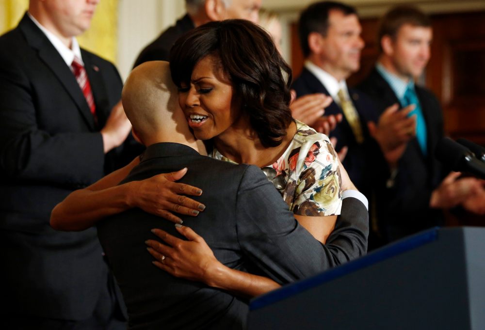 U.S. first lady Michelle Obama hugs U.S. Navy veteran David Padilla, who has found employment with a transport company after leaving military service, during an event in the East Room of the White House in Washington, April 30, 2013. Obama announced...