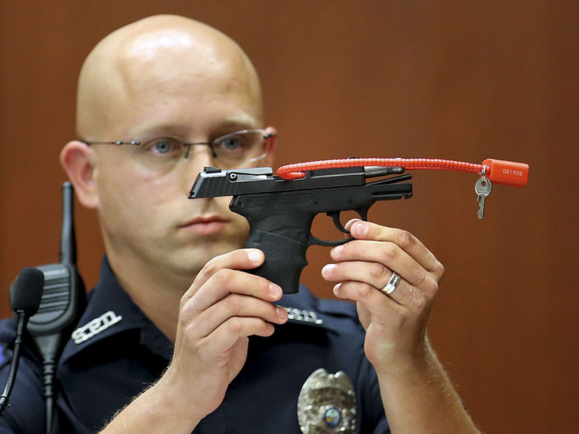 Sanford police officer Timothy Smith holds up the gun that was used to  kill Trayvon Martin, while testifying during George Zimmerman's murder trial in Seminole circuit court in Sanford, Florida, June 28, 2013. (Photo by Joe Burbank/Reuters)