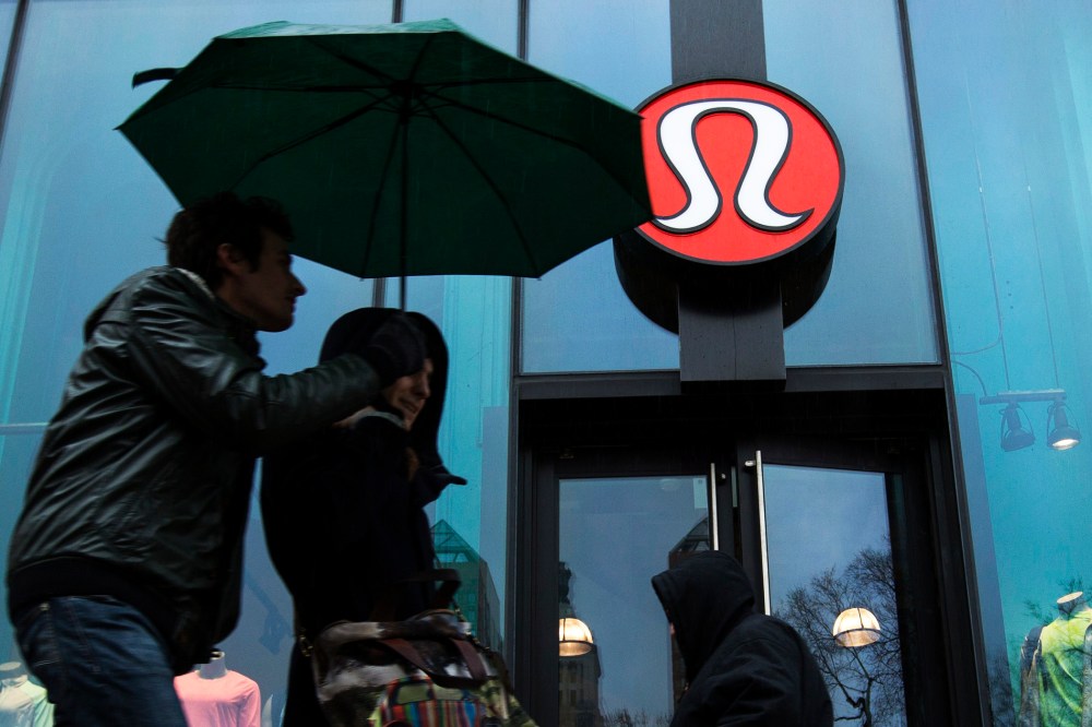 Pedestrians walk past a Lululemon Athletica store in New York, Mar. 19, 2013.