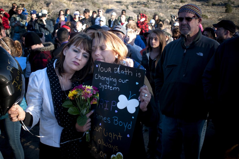 Star Garrett, left, and Shannon Haley, second from left, embrace during the vigil for James Boyd Albuquerque on April 2, 2014.