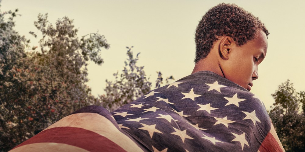 Image: Back of an Black boy wearing an American flag.
