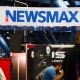 Signage for the Newsmax conservative television broadcasting network is displayed at a broadcast TV booth at the National Rifle Association (NRA) annual meeting at the George R. Brown Convention Center, in Houston, Texas on May 28, 2022.