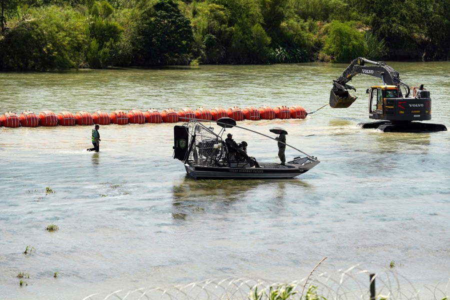 Texas State Troopers watch from an airboat as workers deploy a string of large buoys to be used as a border barrier at the center of the Rio Grande near Eagle Pass, Texas, Tuesday, July 11, 2023. The floating barrier is being deployed in an effort to block migrants from entering Texas from Mexico. (AP Photo/Eric Gay)