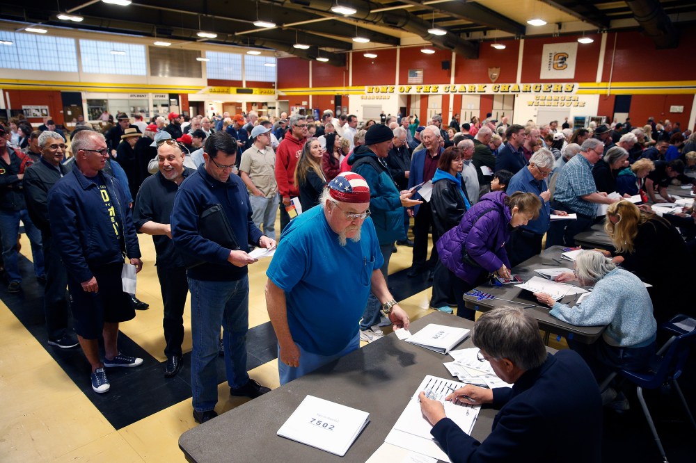 crowds of people line up to get a ballot at a Republican caucus site