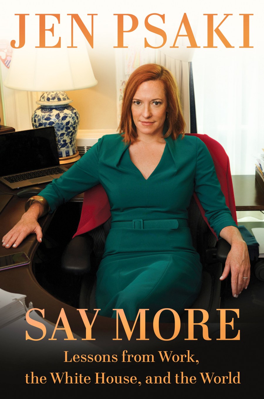 On her book cover, Jen Psaki sits at a computer desk in a green dress